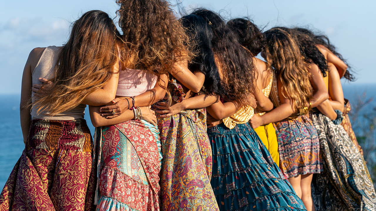 Grupo de mujeres abrazadas mirando al mar