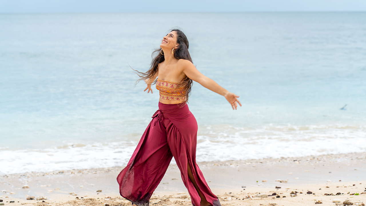 Mujer caminando libre por la orilla del mar