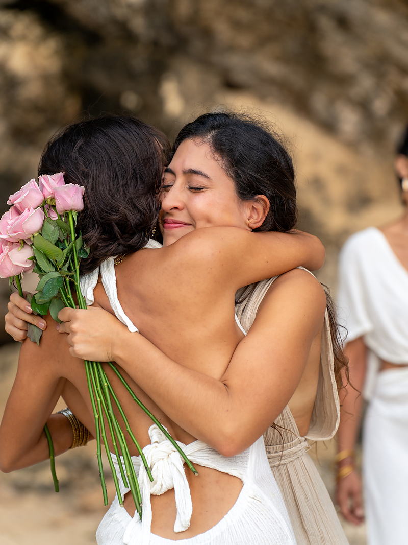 Dos mujeres abrazándose con flores